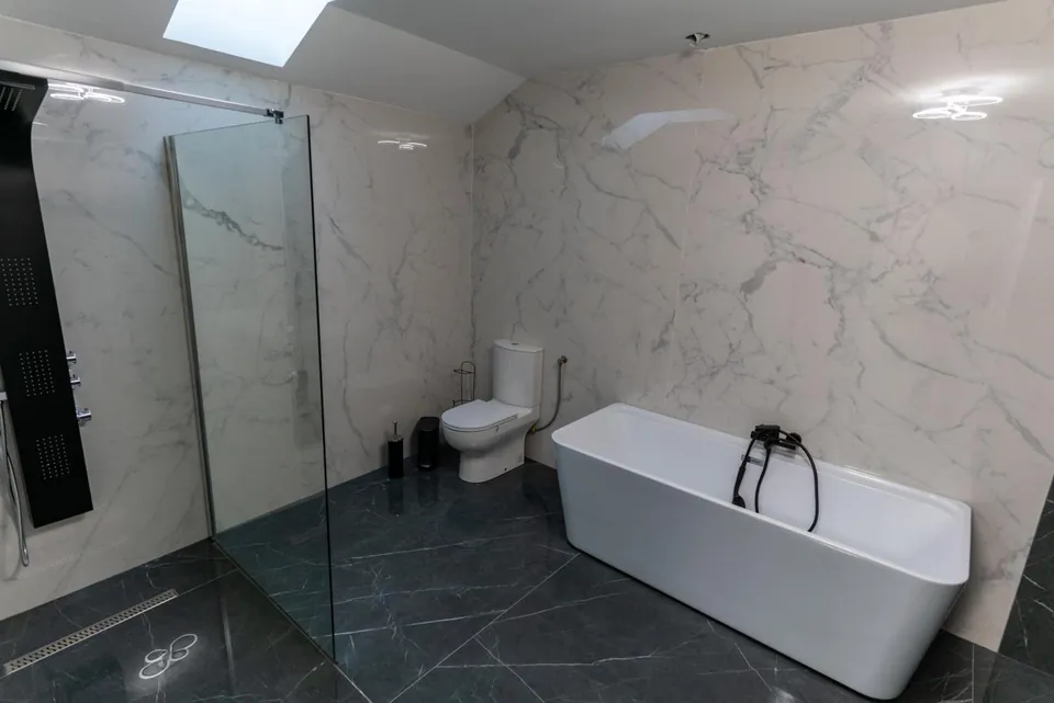 Baie cu cadă freestanding și duș cu pereți de sticlă