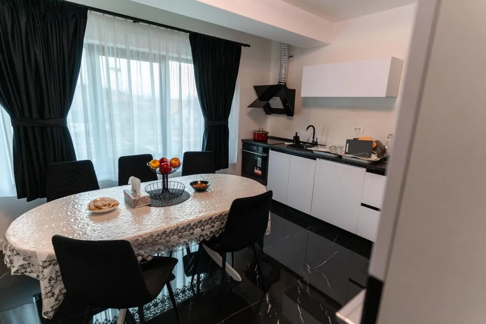Bucătărie modernă cu loc de luat masa și fereastră mare