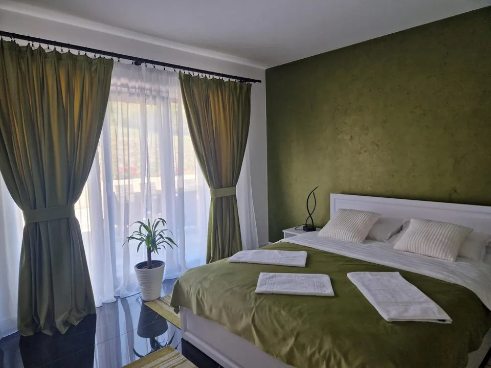Cameră dublă cu perete verde-olive și draperii asortate