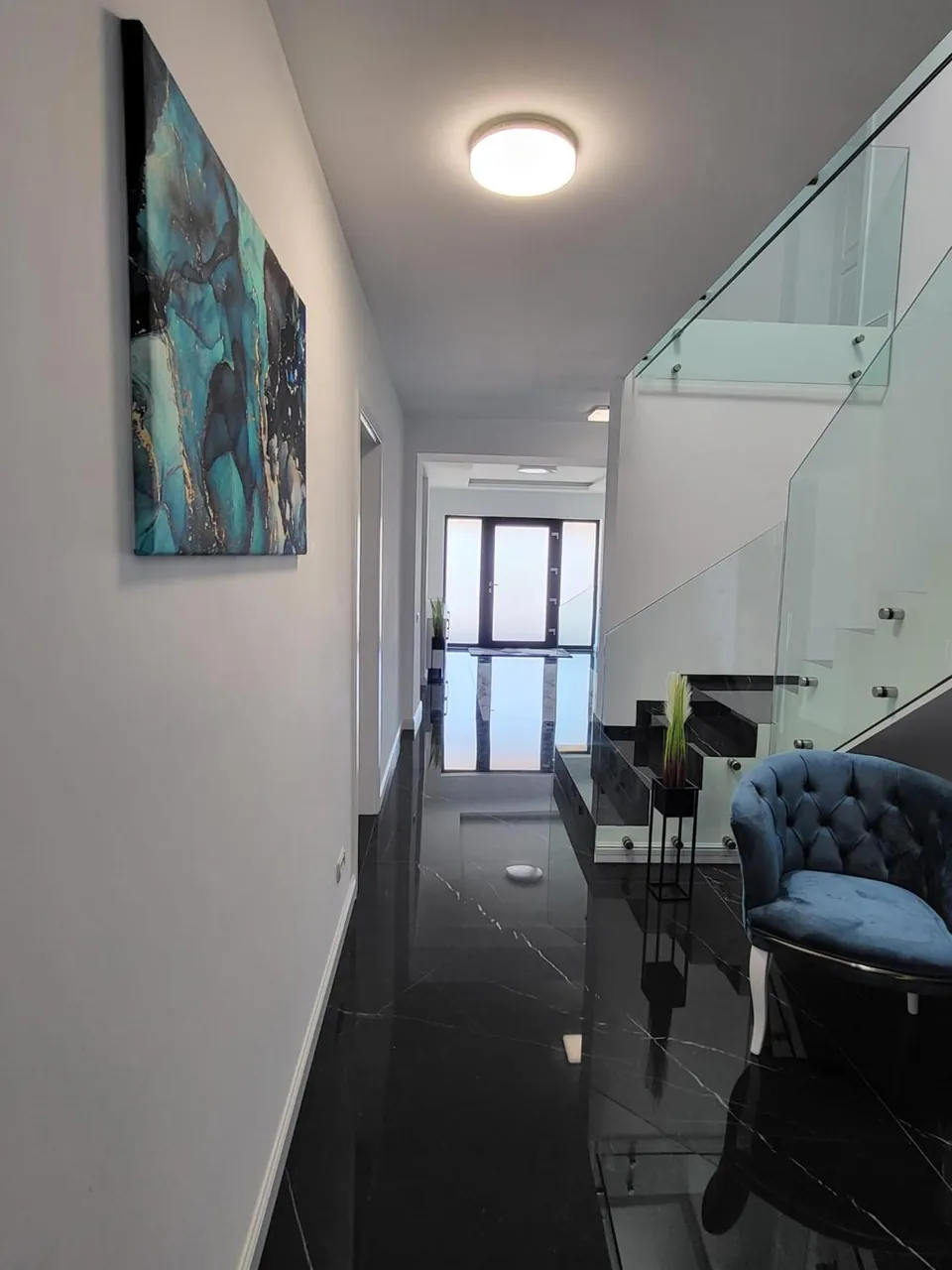 Coridor cu tablou modern și pardoseală neagră lucioasă