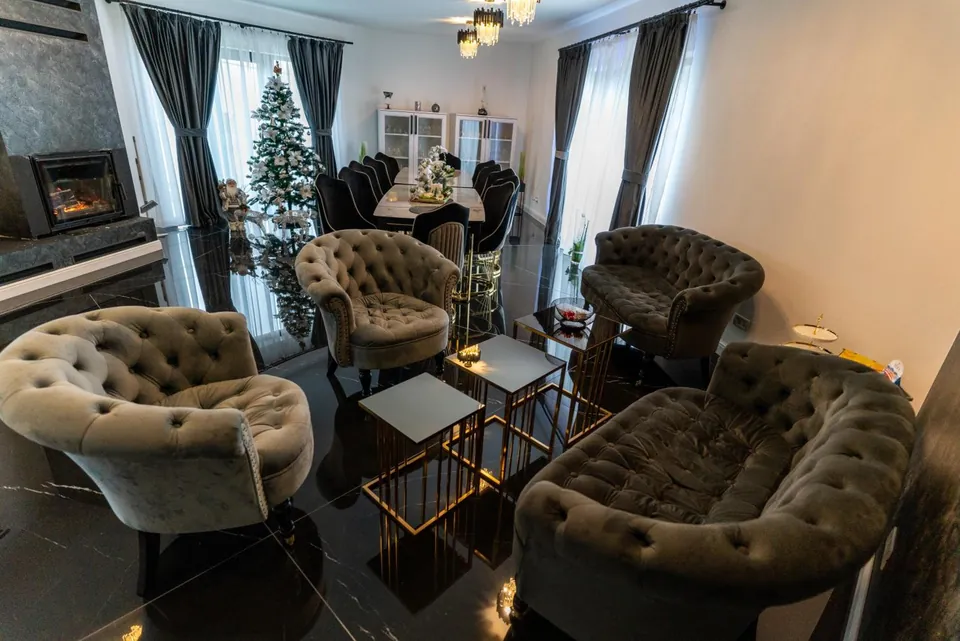 Lounge comun cu fotolii capitonate lângă șemineu