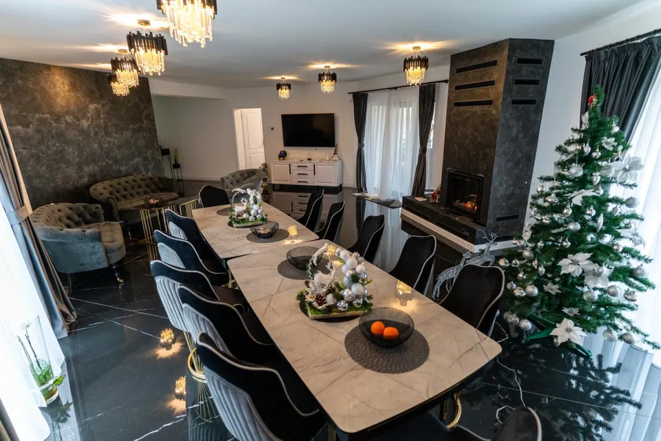 Salon de mese cu masă lungă, candelabre de cristal și șemineu
