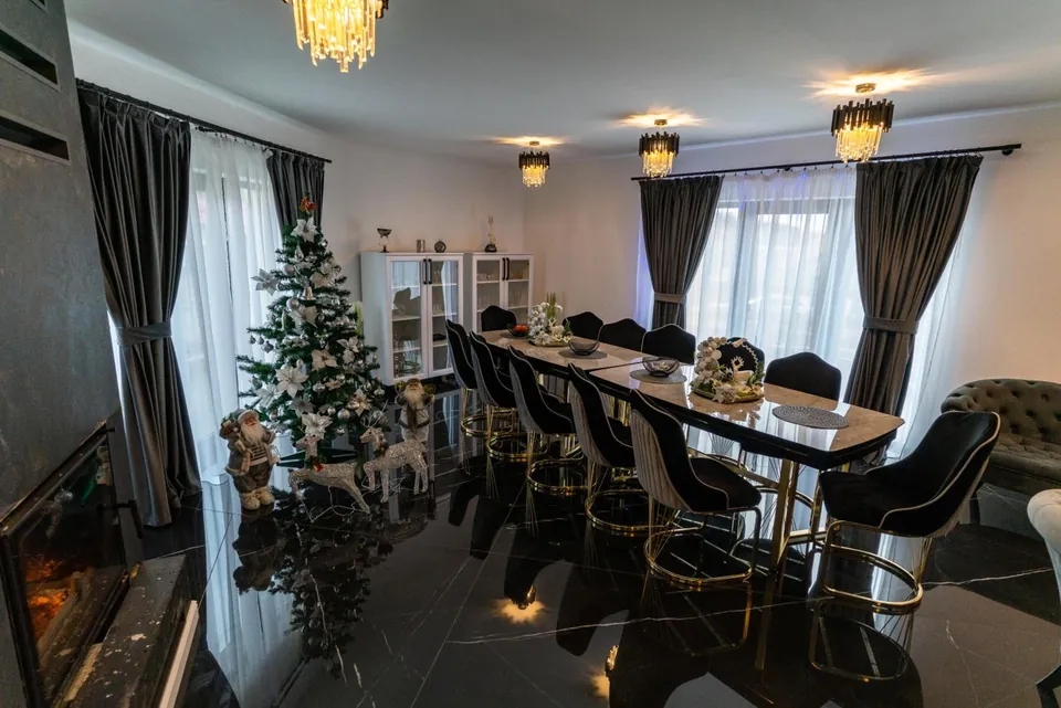 Salonul de mese decorat de Crăciun, cu brad și șemineu