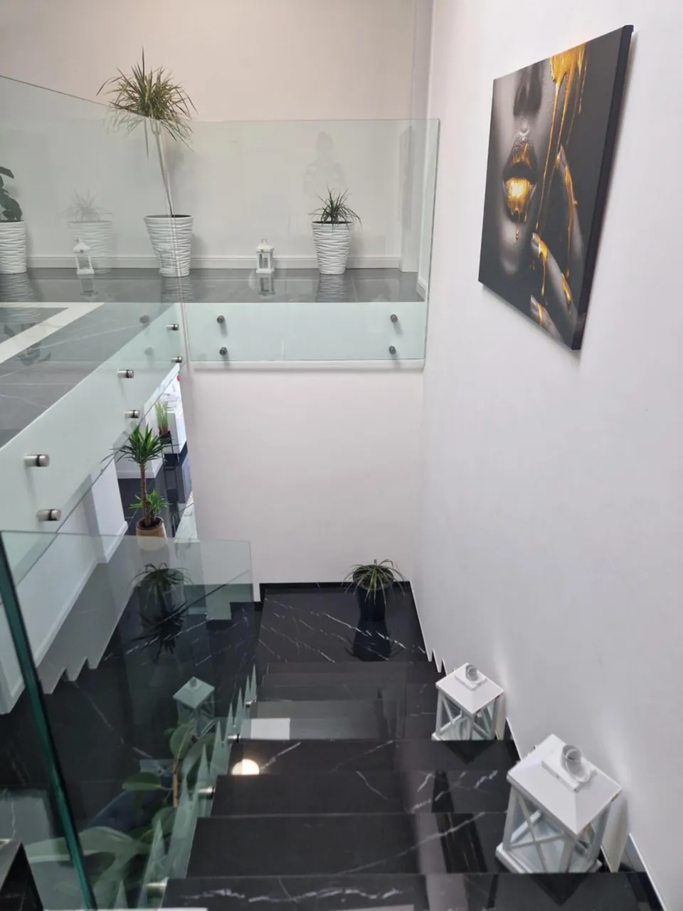 Scara interioară cu balustradă din sticlă și decor minimalist